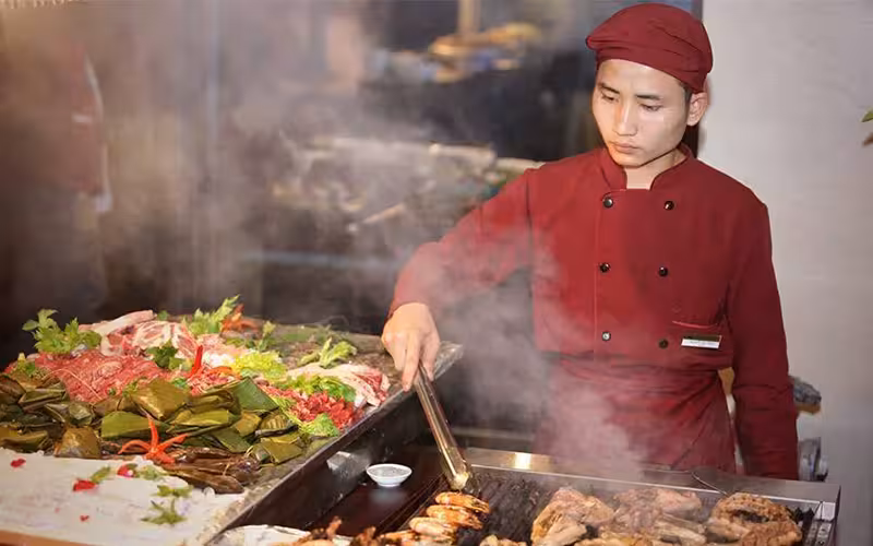Đầu bếp nhà hàng đang chế biến hải sản tươi ngon trên bếp nướng